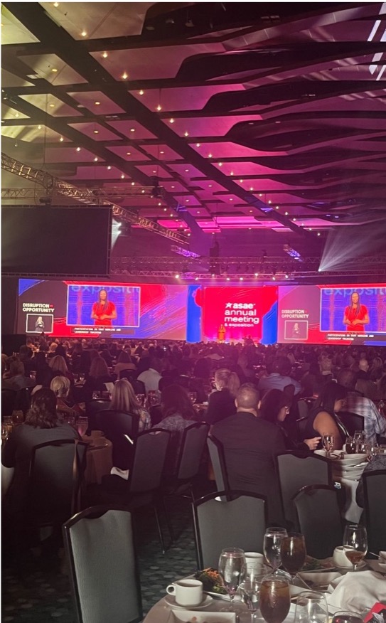 Photograph of attendees at their tables at ASAE Annual Conference 2022 looking at the speaker on stage.