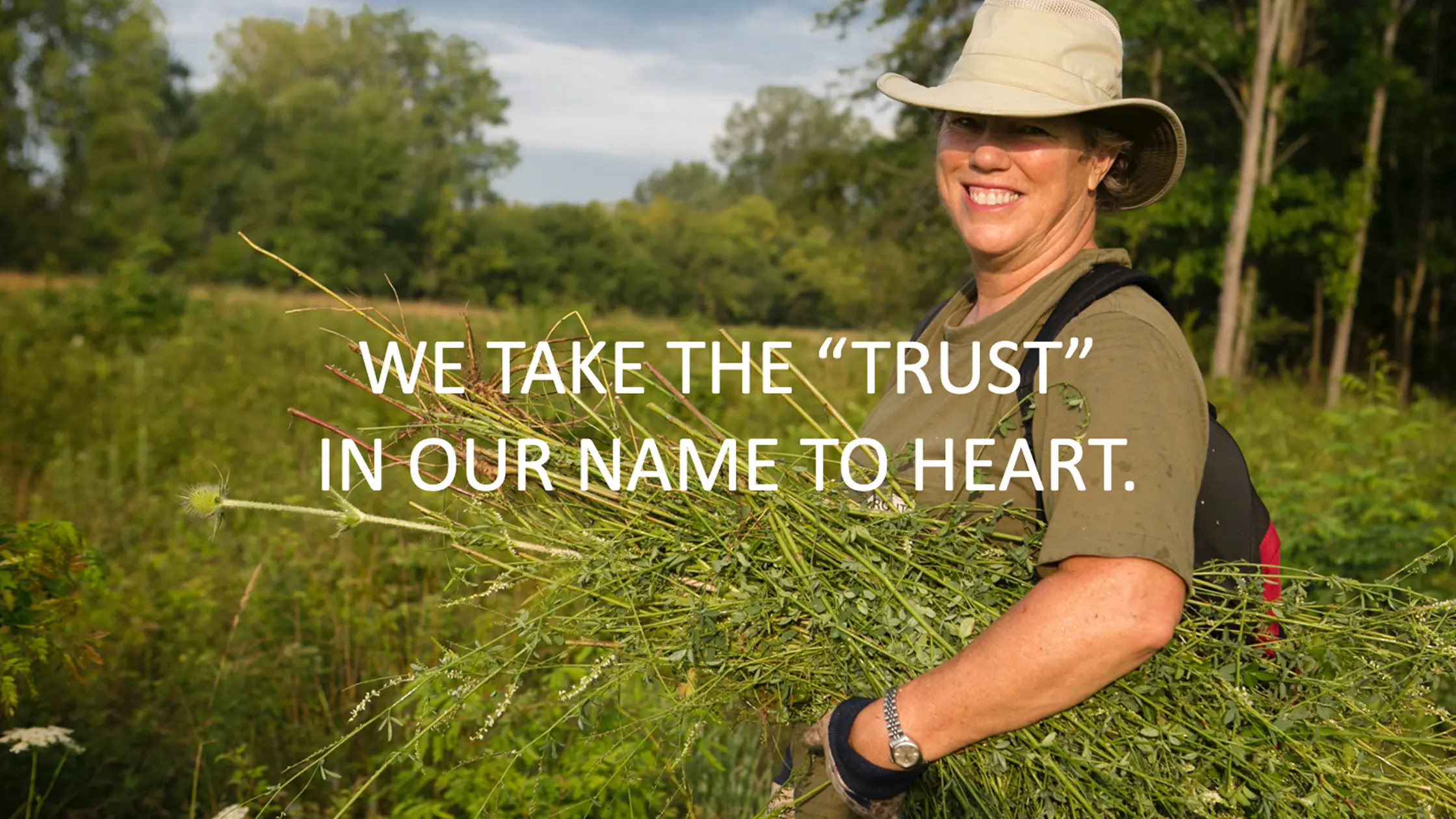 We take the trust in our name to heart. Woman in a field holding wheat.
